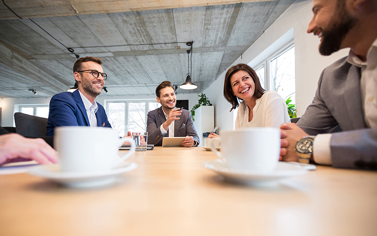 Business people around a conference table with coffee cups